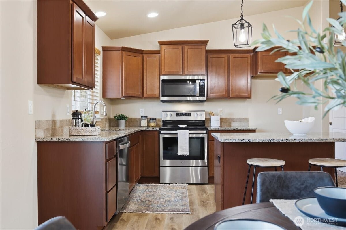 3709 Morehouse Place Pasco, WA 99301 - Photo 13 of 32 a kitchen with stainless steel appliances granite countertop a stove top oven a sink and a microwave