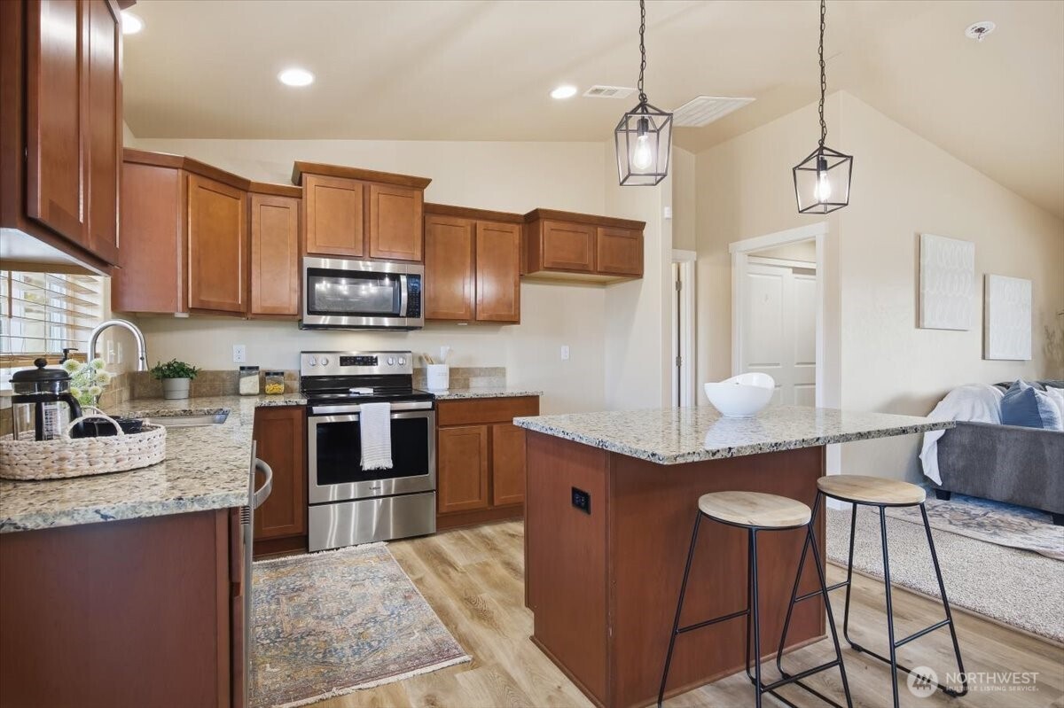 3709 Morehouse Place Pasco, WA 99301 - Photo 14 of 32 a kitchen with stainless steel appliances granite countertop a stove a sink a microwave a refrigerator and cabinets