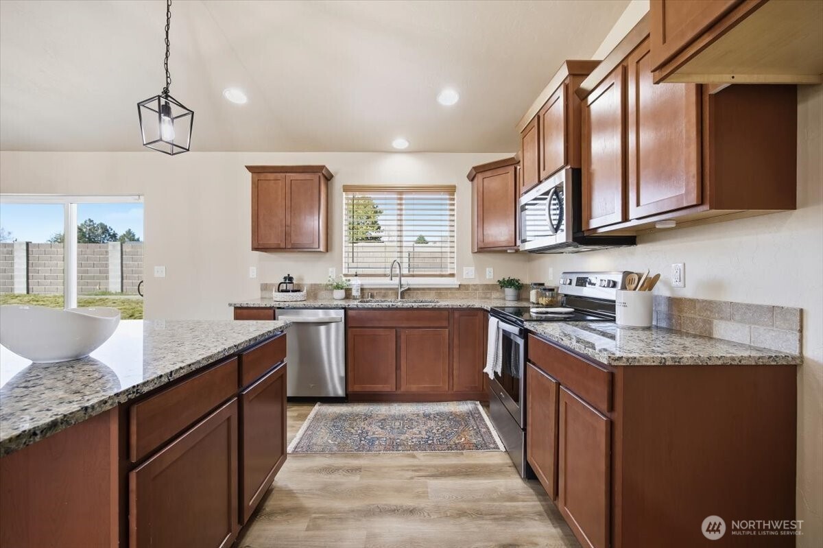 3709 Morehouse Place Pasco, WA 99301 - Photo 16 of 32 a kitchen with stainless steel appliances granite countertop a sink stove and refrigerator