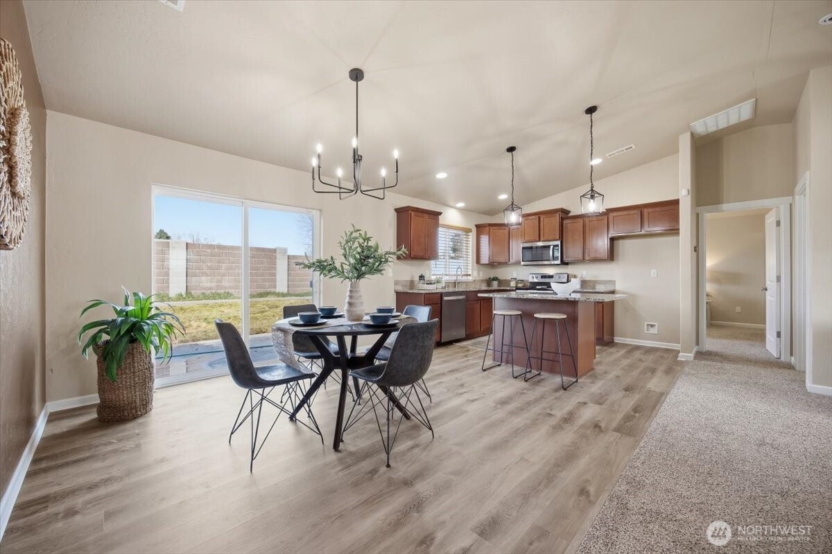 3709 Morehouse Place Pasco, WA 99301 - Photo 8 of 32 a view of a dining room and livingroom with furniture wooden floor a chandelier