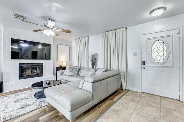 a living room with furniture a fireplace and a flat screen tv