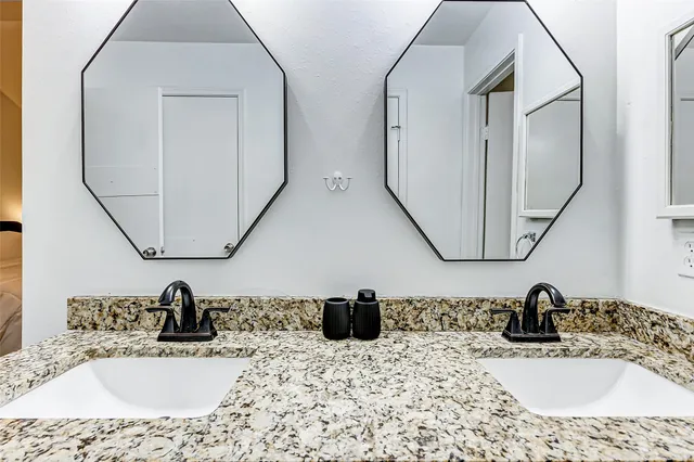 a bathroom with double vanity sinks and a mirror