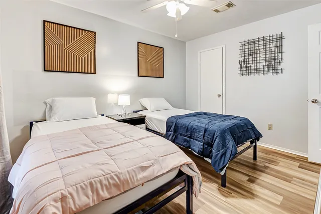 a bedroom with two beds and painting on the wall