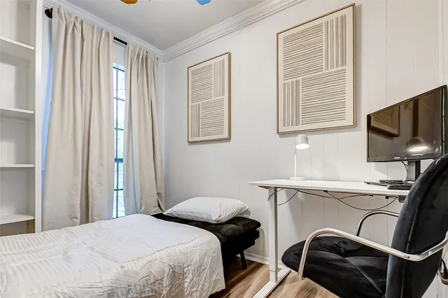 a bedroom with a bed window and a flat screen tv