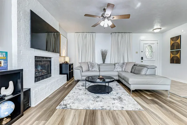 a living room with furniture a fireplace and a flat screen tv