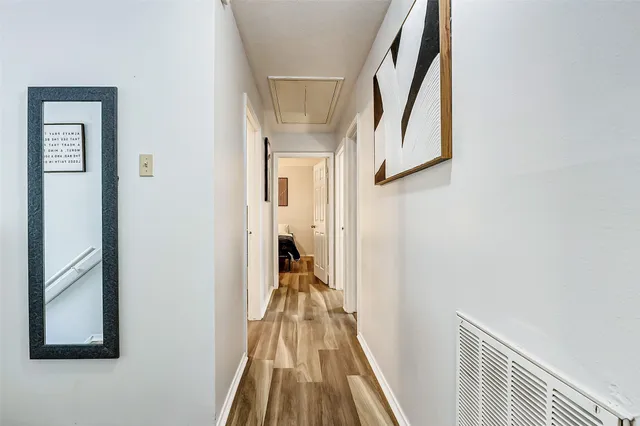 a view of a hallway with wooden floor and entryway