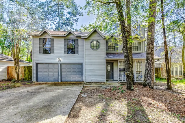 a view of a brick house with large windows and a large tree