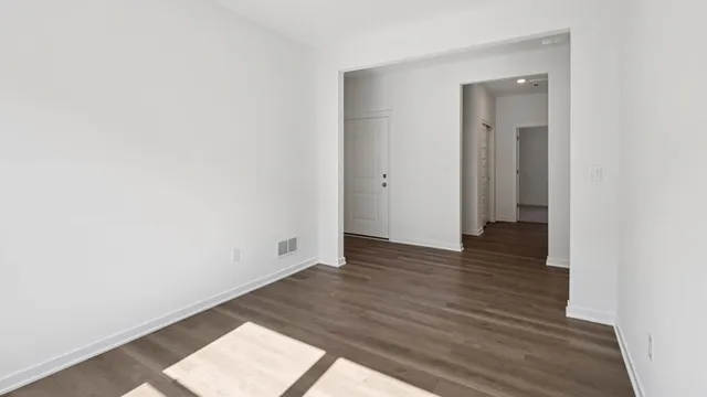 a view of an empty room and wooden floor