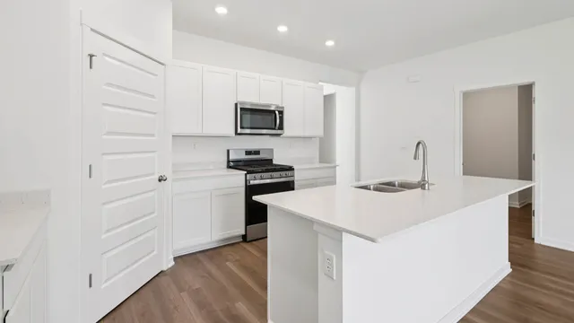 a kitchen with appliances a sink and cabinets