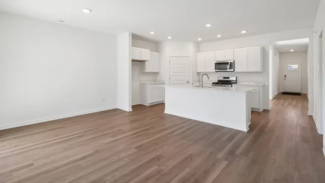 a view of kitchen with wooden floor and electronic appliances