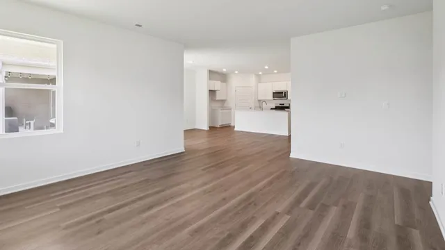 a view of a kitchen with wooden floor and a window