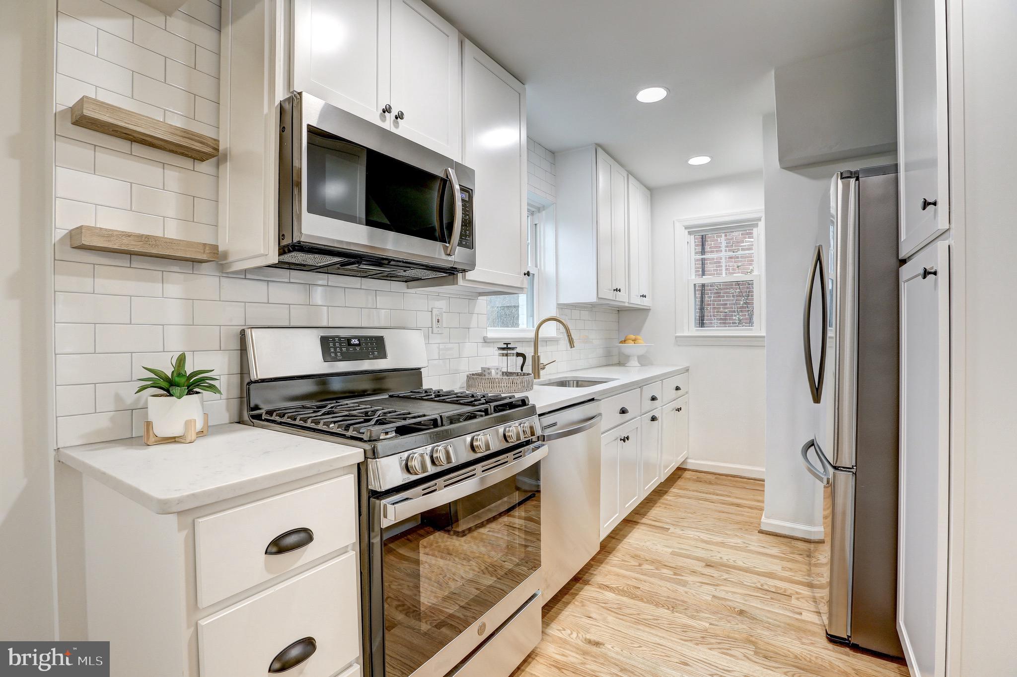 2116 Forest Glen Road Silver Spring, MD 20910 - Photo 15 of 57 a kitchen with stainless steel appliances a stove microwave and refrigerator