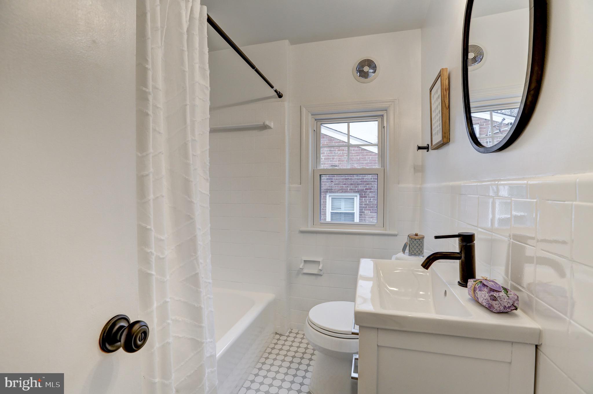 2116 Forest Glen Road Silver Spring, MD 20910 - Photo 32 of 57 a bathroom with a toilet a sink and a mirror