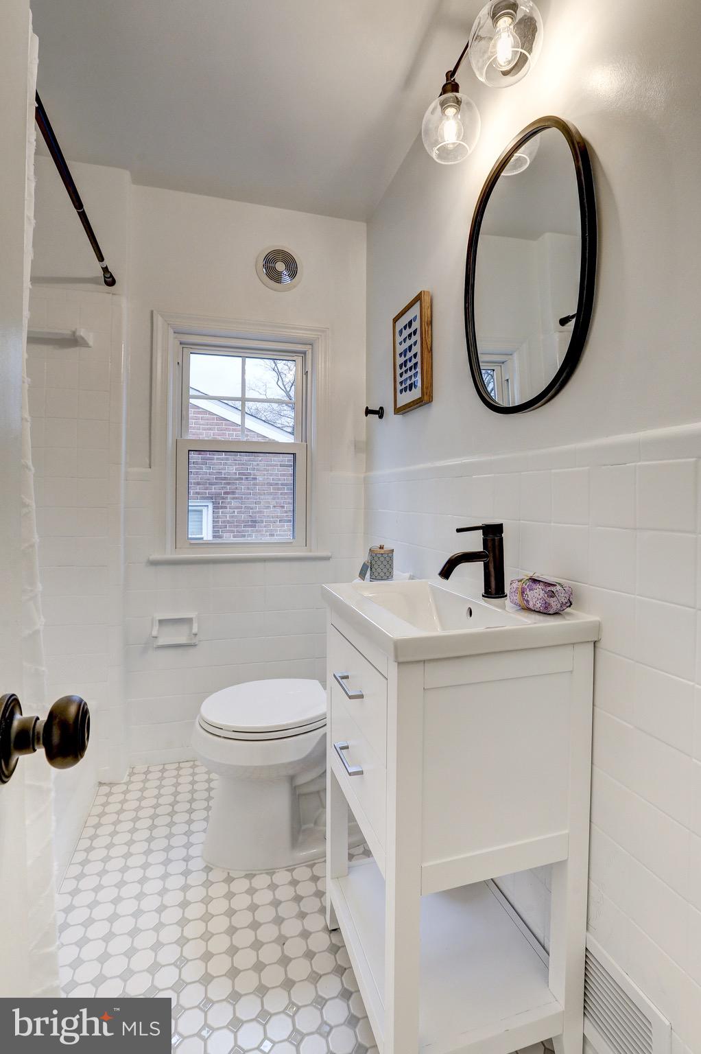 2116 Forest Glen Road Silver Spring, MD 20910 - Photo 34 of 57 a bathroom with a sink a mirror and a toilet