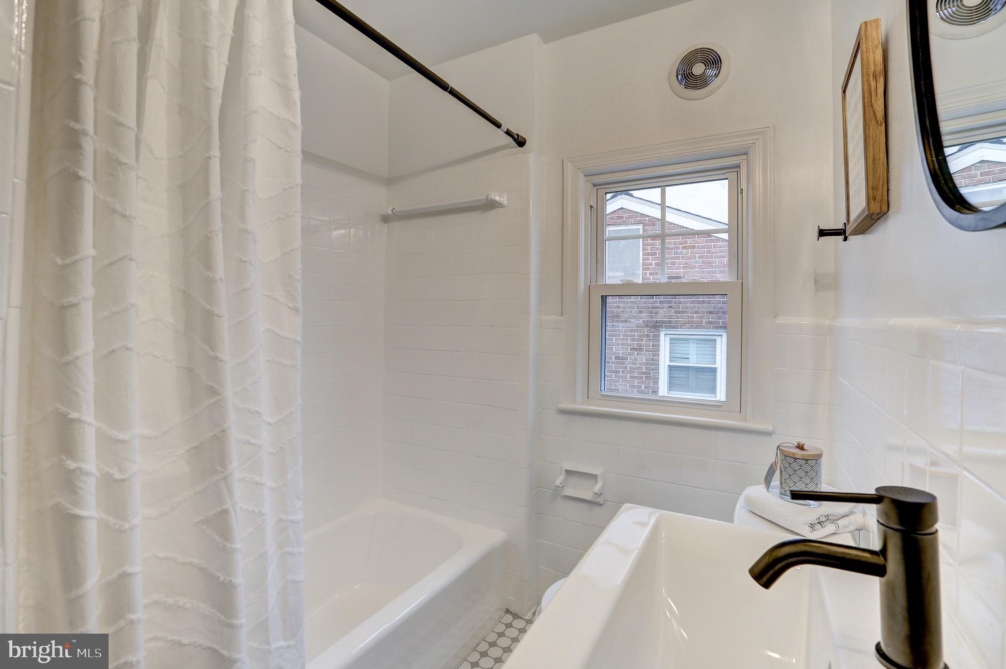 2116 Forest Glen Road Silver Spring, MD 20910 - Photo 35 of 57 a bathroom with a sink a window and a shower