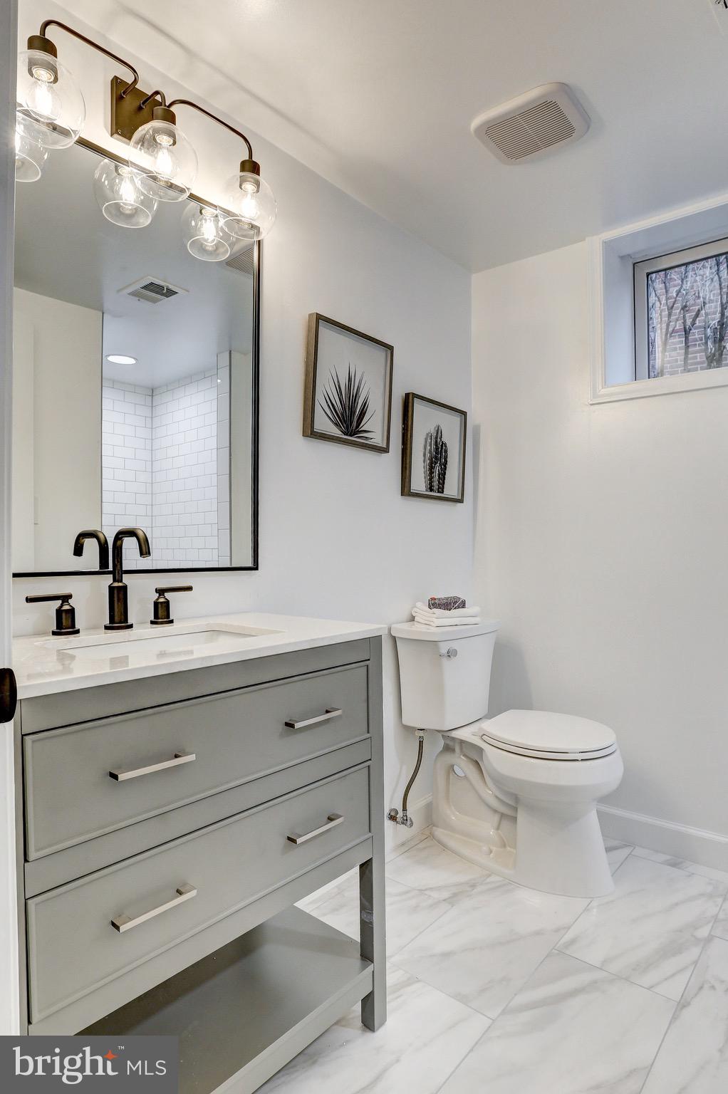 2116 Forest Glen Road Silver Spring, MD 20910 - Photo 48 of 57 a bathroom with a toilet a sink and mirror