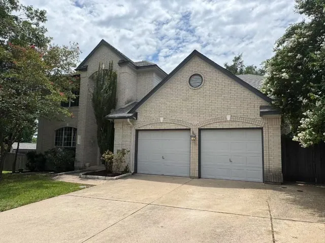 a front view of house with garage and trees