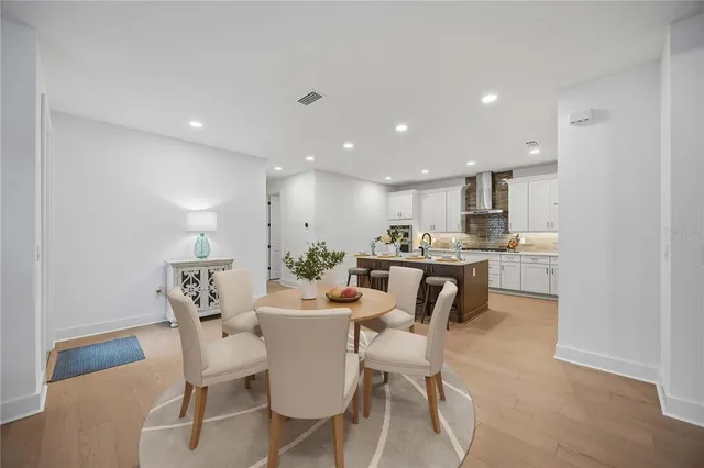 a large living room with stainless steel appliances kitchen island granite countertop furniture and a flat screen tv