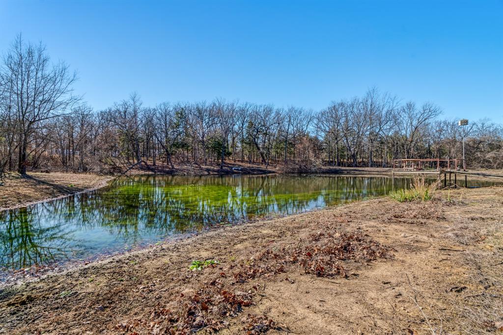 1431 County Road Paris, TX 75462 - Photo 21 of 27 a view of a lake with a big yard and large trees