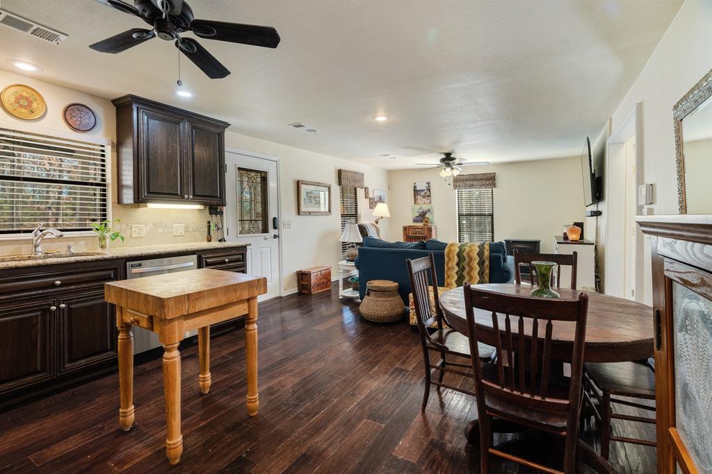 1431 County Road Paris, TX 75462 - Photo 8 of 27 a open kitchen with stainless steel appliances granite countertop a stove a refrigerator a dining table and chairs with wooden floor