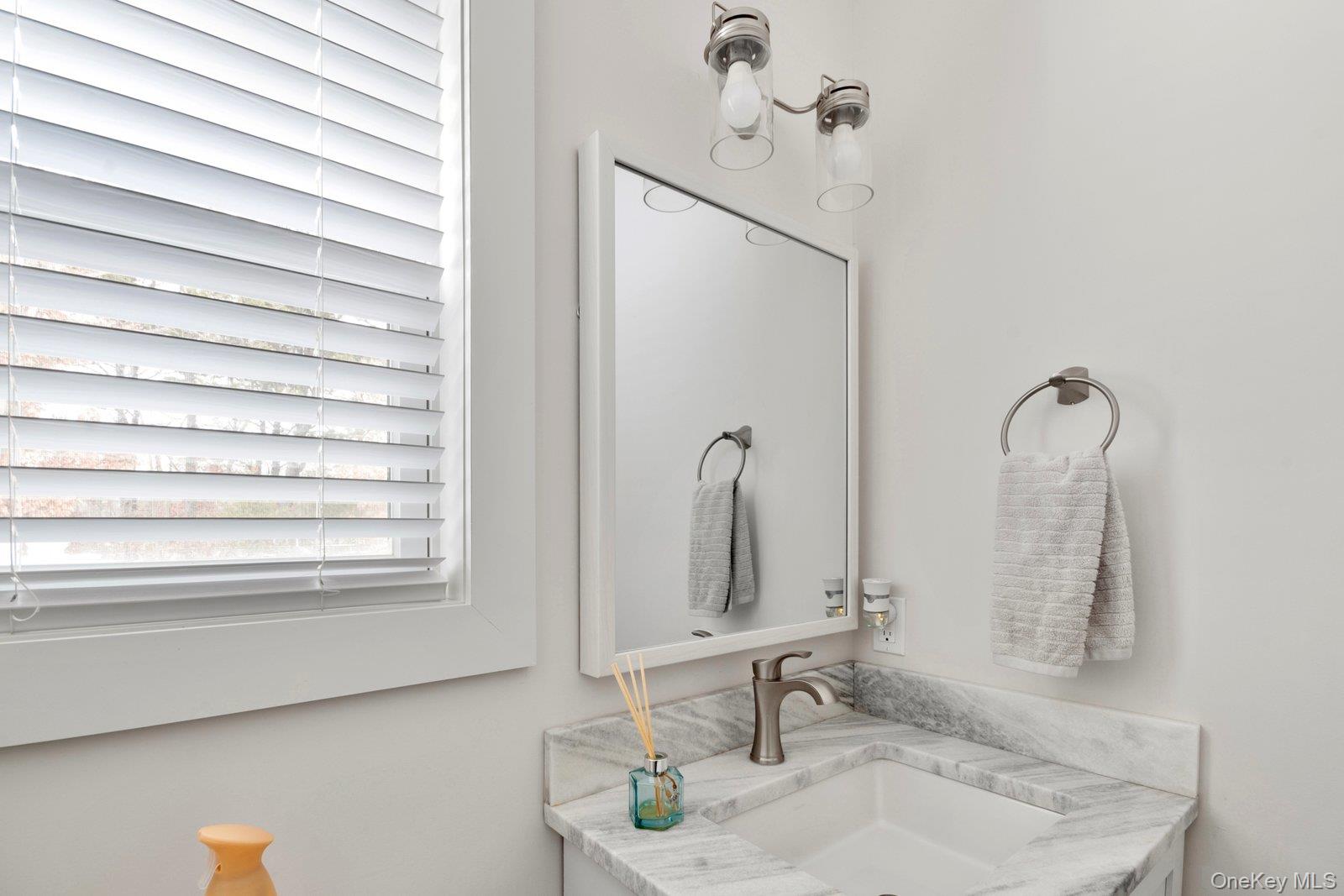 65 Doane Avenue Bellport, NY 11713 - Photo 15 of 37 a bathroom with a sink and a mirror