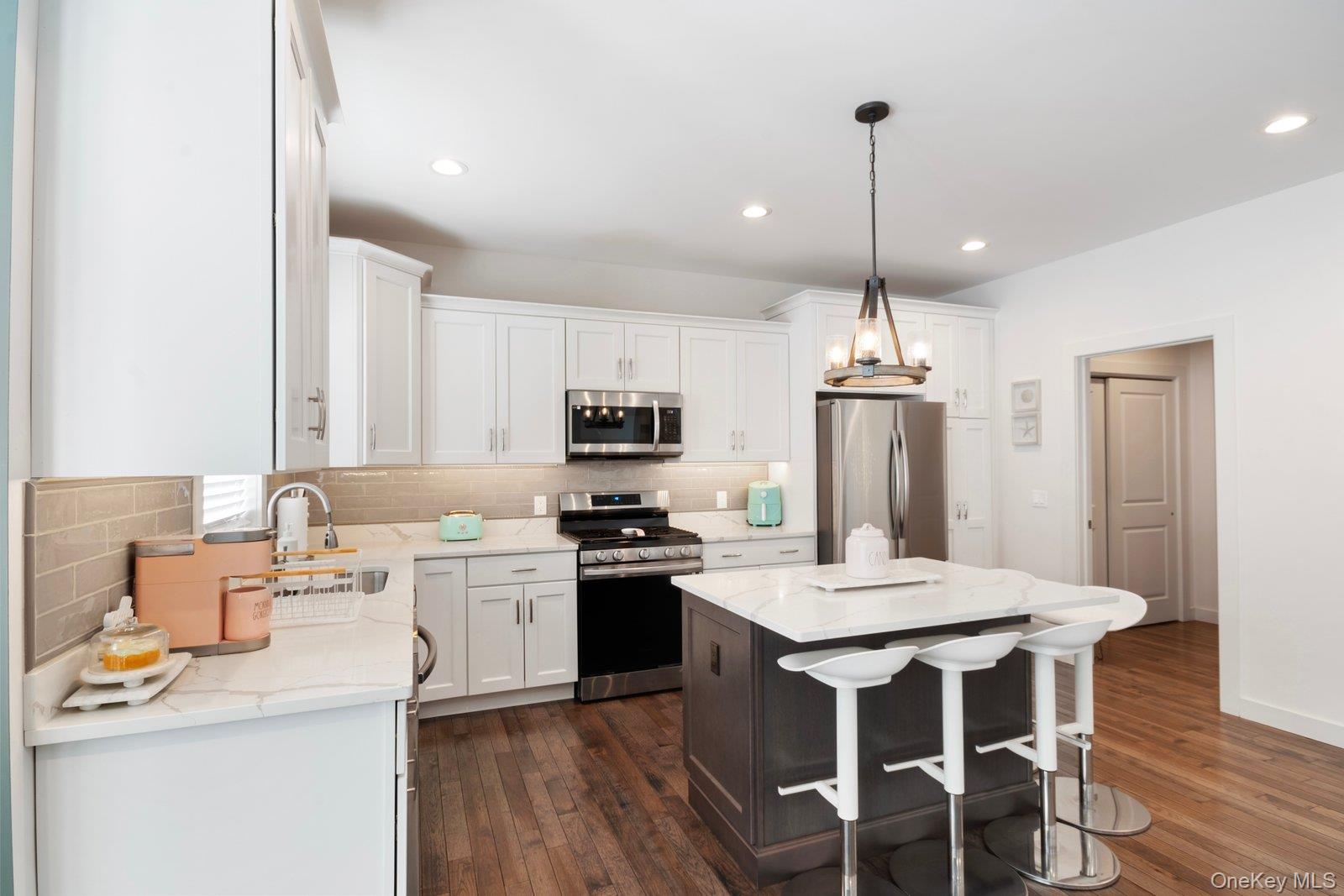 65 Doane Avenue Bellport, NY 11713 - Photo 9 of 37 a kitchen with kitchen island granite countertop a sink stove and refrigerator