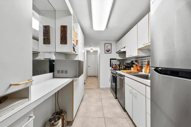 a kitchen with stainless steel appliances a sink and a refrigerator