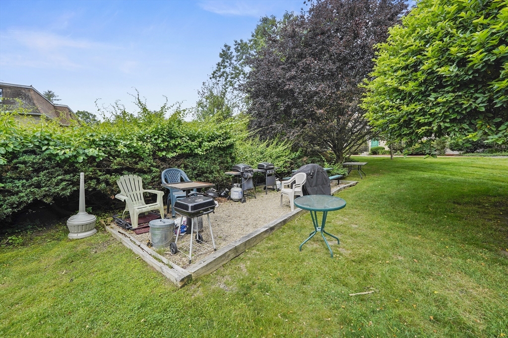 220 Swanson Road, Unit 605 Boxborough, MA 01719 - Photo 20 of 24 a view of a garden with a bench and some trees