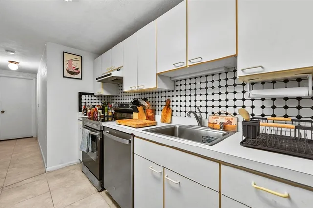 a kitchen with a sink a stove and cabinets