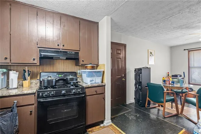 a kitchen with stainless steel appliances granite countertop a stove refrigerator and cabinets