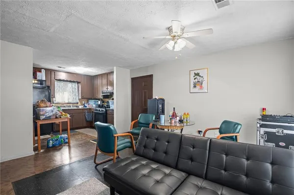 a living room with furniture and a ceiling fan