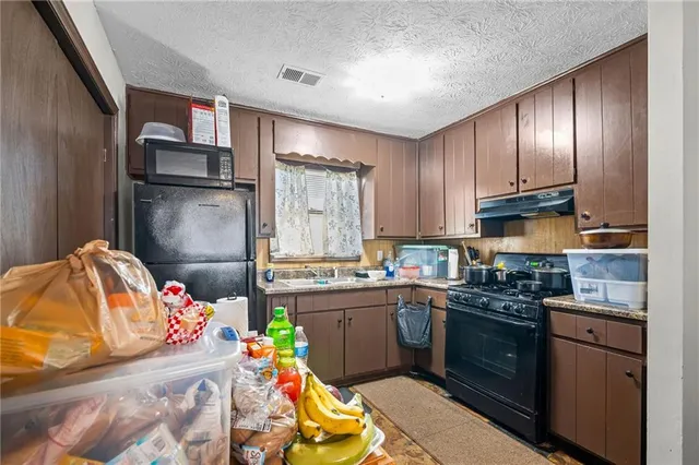 a kitchen with granite countertop stainless steel appliances and wooden cabinets
