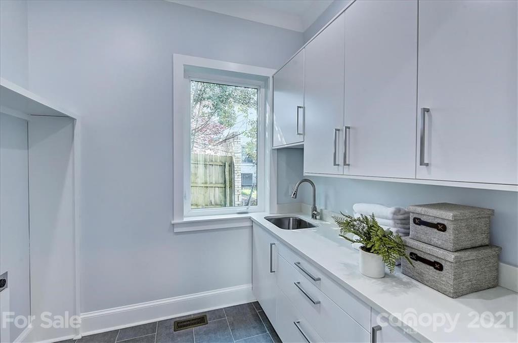 2011 Providence Road Charlotte, NC 28211 - Photo 15 of 37 a kitchen with stainless steel appliances granite countertop a sink a stove and white cabinets