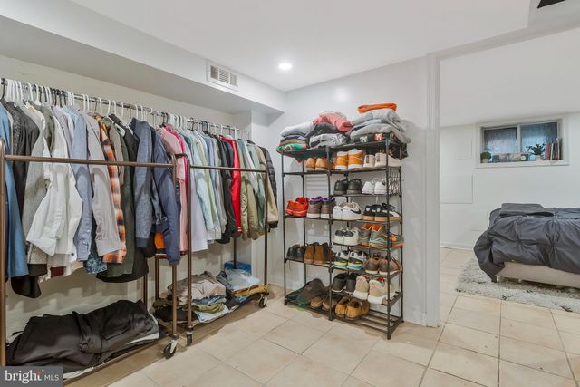 a view of walk in closet with clothes