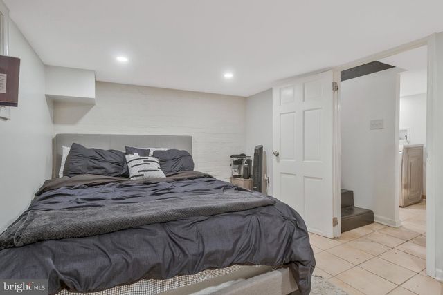 a bedroom with a bed and a refrigerator