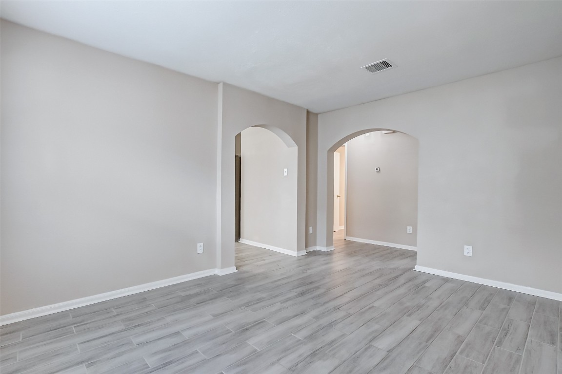 10822 Cane Grove Lane Houston, TX 77075 - Photo 11 of 44 an empty room with wooden floor and mirror