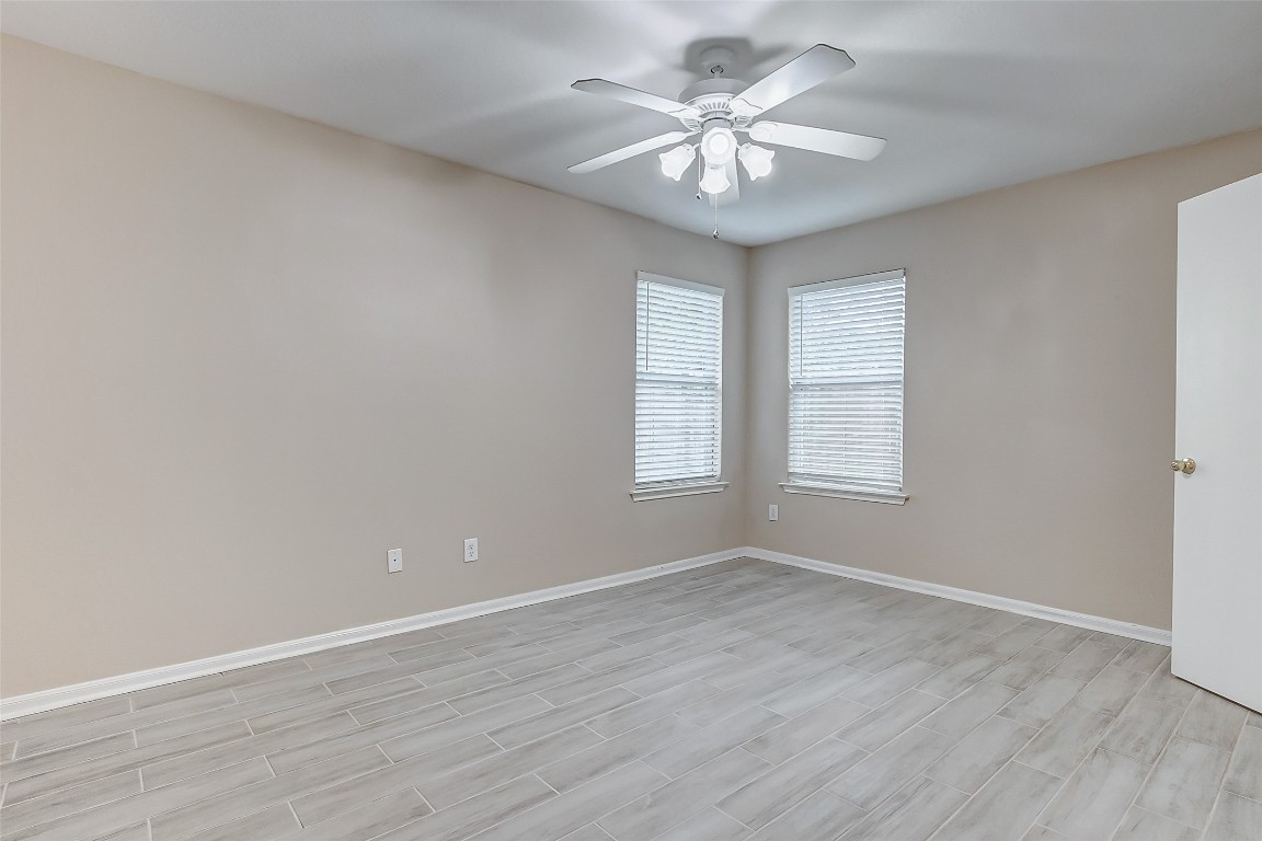 10822 Cane Grove Lane Houston, TX 77075 - Photo 15 of 44 an empty room with wooden floor and windows