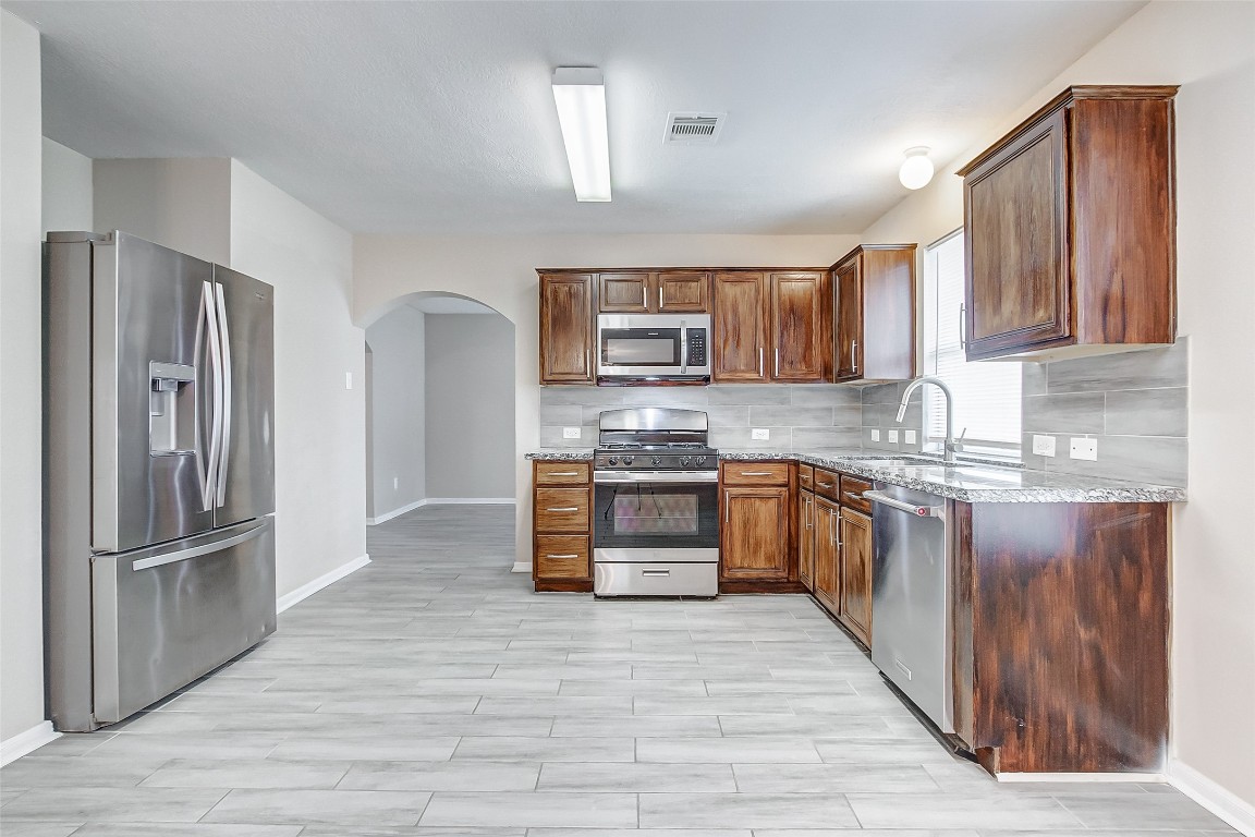 10822 Cane Grove Lane Houston, TX 77075 - Photo 18 of 44 a kitchen with stainless steel appliances granite countertop a refrigerator and a stove top oven