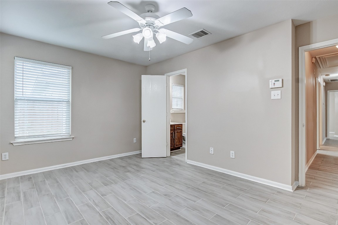 10822 Cane Grove Lane Houston, TX 77075 - Photo 24 of 44 an empty room with wooden floor chandelier fan and windows