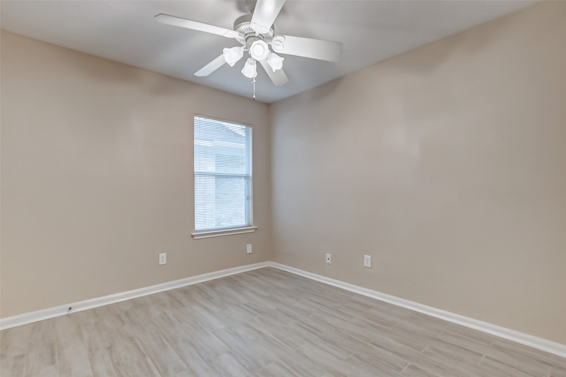 10822 Cane Grove Lane Houston, TX 77075 - Photo 37 of 44 an empty room with wooden floor and windows