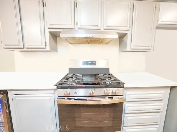 a stove top oven sitting inside of a kitchen