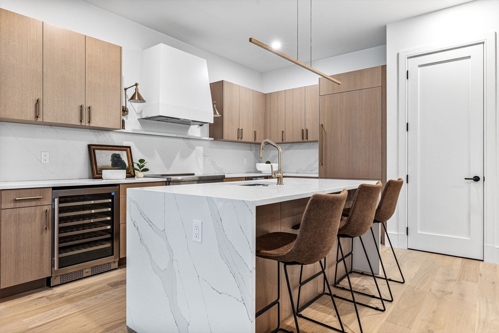 1114 Beacon Street, Unit 206 Newton, MA 02461 - Photo 12 of 39 a kitchen with a table chairs refrigerator and cabinets