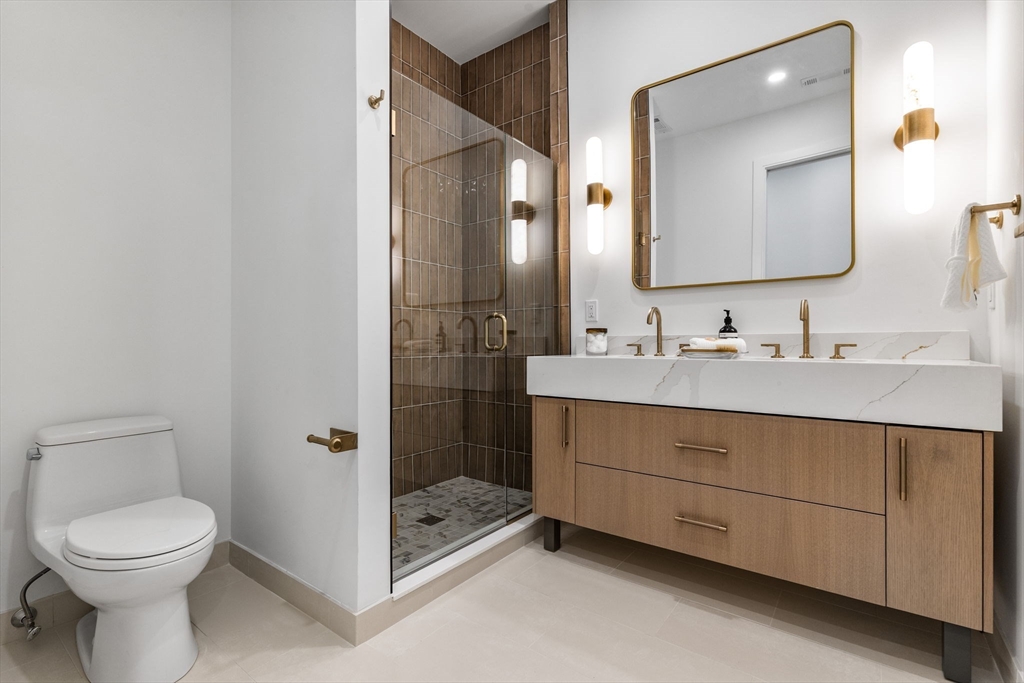 1114 Beacon Street, Unit 206 Newton, MA 02461 - Photo 29 of 39 a bathroom with a toilet a sink and mirror