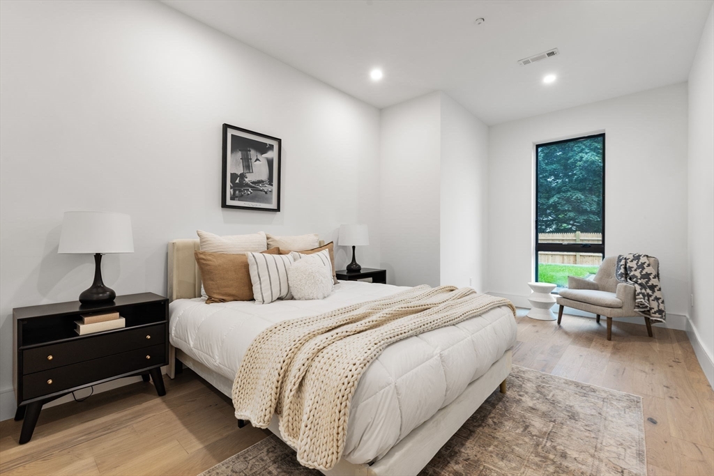 1114 Beacon Street, Unit 206 Newton, MA 02461 - Photo 30 of 39 a bedroom with a bed and wooden floor
