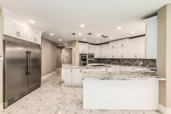 a view of kitchen with kitchen island a sink stainless steel appliances and cabinets
