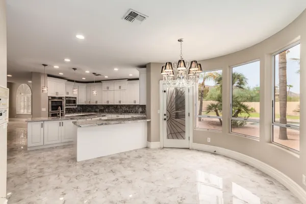 a open kitchen with white cabinets and refrigerator