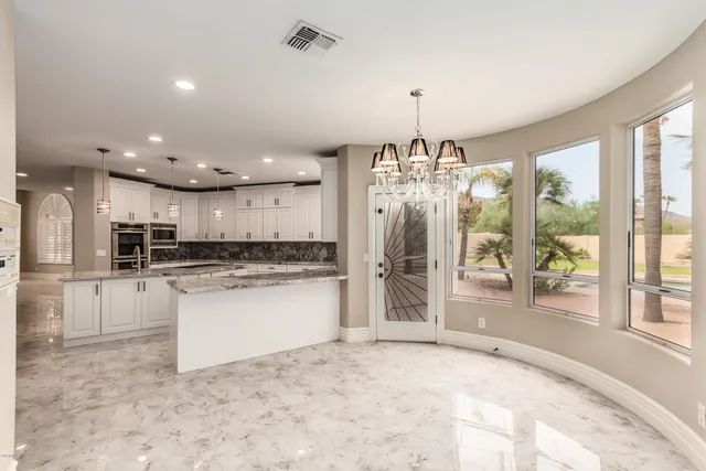 a open kitchen with white cabinets and refrigerator