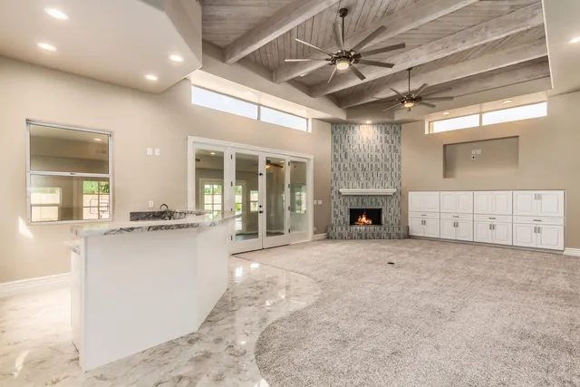 a view of an empty room with a fireplace and a window
