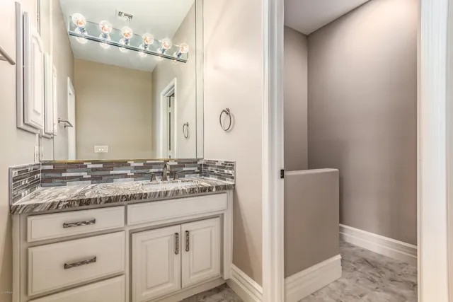 a bathroom with a granite countertop sink and a mirror