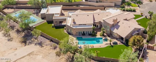 an aerial view of a house with a garden and lake view
